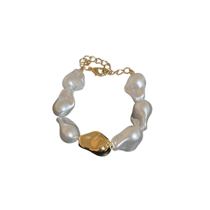 Bracelet en perles baroques élégant avec perle dorée et chaîne d'extension sur fond blanc