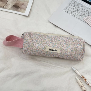 Detailed view of floral canvas stationery bag with pink handle and metal zipper closure