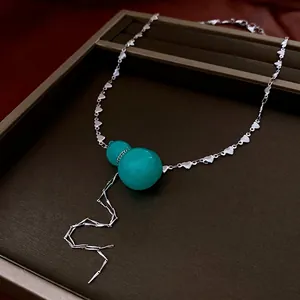 Elegant green gourd necklace with heart-shaped chain and silver tassel in gift box