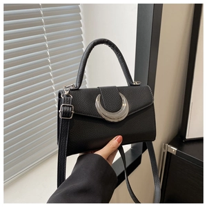 Détail du sac à main en cuir grainé avec quincaillerie argentée en forme de croissant