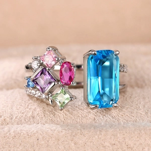 Macro detail of silver ring with large blue zircon and colorful gemstone cluster settings