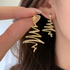Gold-plated star Christmas tree earrings with pavé zircons worn on ear for scale