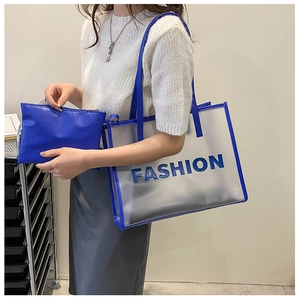 Detail of transparent PVC tote bag with blue leather inner pouch and FASHION lettering