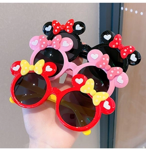 Detail of colorful cartoon sunglasses with round ears and polka dot bows for kids