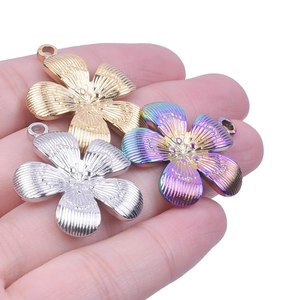 Detail of flower-shaped steel pendants in gold, silver, and rainbow plating