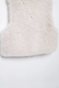 Detailed macro texture of white faux fur vest showcasing soft fibers and material quality
