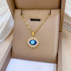 Gros plan détaillé du pendentif œil maléfique avec résine bleue et zircons brillants