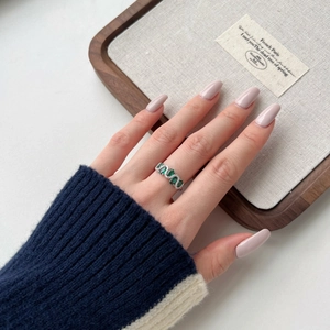 Detail view of S925 silver ring with oval green gemstone and white zircon on hand