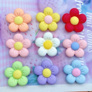 Macro view of nine matte resin flower charms in various colors for DIY crafts