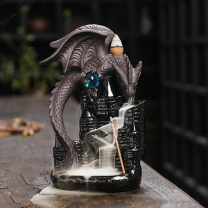 Dragon castle backflow incense burner with blue bead on rustic wooden table