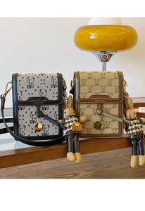 Detail of embroidered canvas phone bags with bear patterns and rabbit pendants