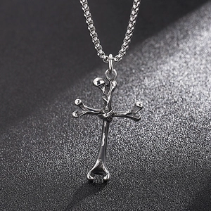 Close-up of a silver cross pendant with bone-shaped metal design and box chain