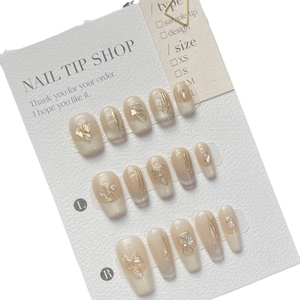 Handmade press-on nails with nude base, gold lines and elegant shell pearl accents
