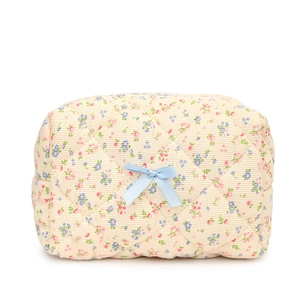 Quilted floral cotton cosmetic bag with a blue bow decoration on a white background