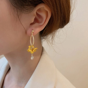 Detail of flower tassel earring with golden metal oval loop and clear crystal on model
