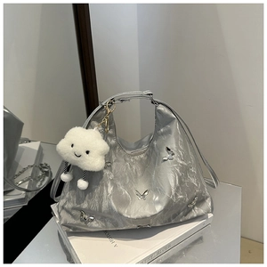 Silver metallic shoulder bag with butterfly detail and white plush cloud charm on books