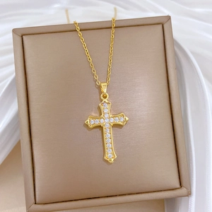 Elegant gold titanium steel cross necklace with sparkling zircons on white silk