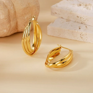 Detailed view of 316L gold triple hoop earrings with a polished finish and pin closure