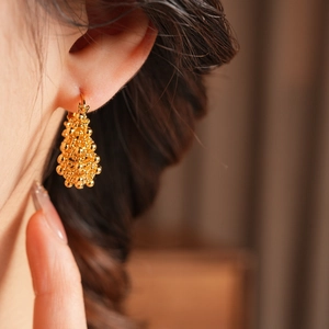 Détail de boucles d'oreilles vintage en or 18 carats avec surface granulaire texturée