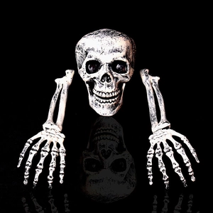 Realistic Halloween skull and hands stakes set with aged finish on black reflective surface