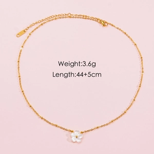 Detailed view of golden stainless steel necklace with white shell flower pendant