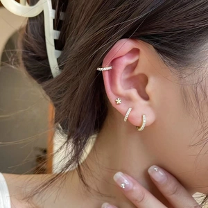 Elegant gold stainless steel hoop earrings with cubic zirconia worn by model