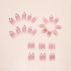 Detail of pink cat eye press-on nails with 3D bows and star pattern stickers