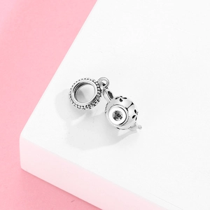 S925 sterling silver teapot charm with hollow flower pattern on pink background