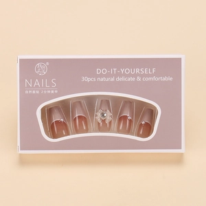 Close-up of pink French press-on nails with 3D bows and pearls on a flat background
