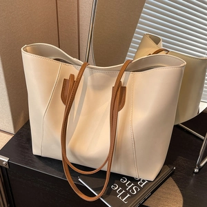 Minimalist cream tote bag with brown straps in a stylish large capacity design