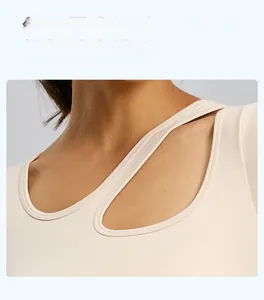 Dettaglio dello scollo asimmetrico traforato su un top da yoga beige da donna