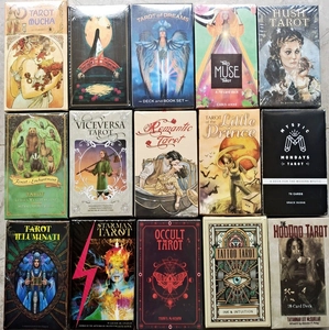 Detailed overhead view of fifteen distinct oracle and tarot card sets in boxes