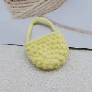 Dettaglio mini ciondolo borsa giallo fatto a mano all'uncinetto con trama a maglia