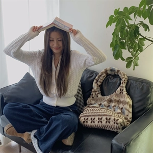 Ethnic plush tote bag with jacquard texture paired with a knit cardigan and jeans