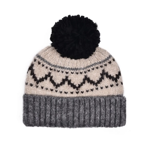 Gros plan sur un bonnet en maille jacquard vintage avec un pompon noir duveteux
