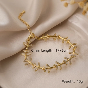 Detail of gold arrow chain bracelet with cubic zirconia on elegant satin fabric