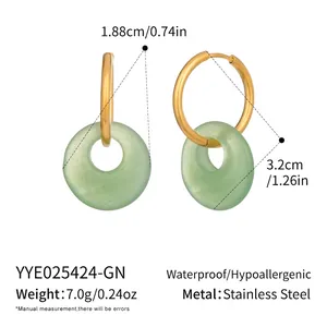 Detail view of gold stainless steel hoop earrings with light green frosted round stone drops