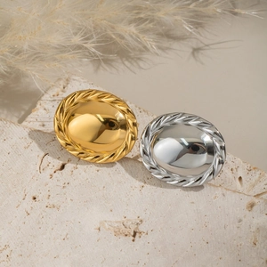 Scalloped oval mirror rings in gold and silver finish on a textured stone pedestal