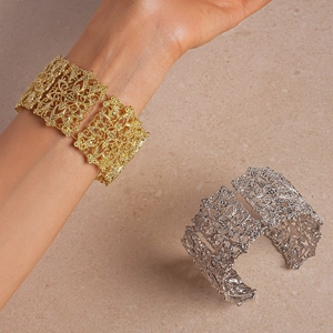 Détails de bracelets larges ajourés dorés et argentés aux motifs floraux rétro
