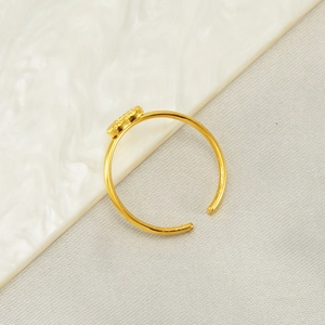 Detailansicht eines verstellbaren goldenen Rings mit feinem Schmetterlingsmotiv