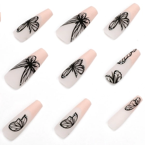 Long coffin nude press-on nails featuring detailed black butterfly wing patterns