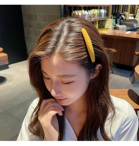 Detail of yellow seamless hair comb clip worn on model's hair for a secure fit