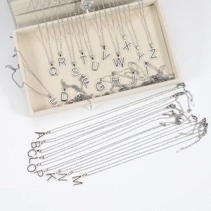 Polished stainless steel necklace with 26-letter alphabet pendants on velvet jewelry box