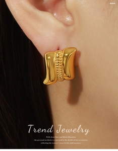 Detailed close-up of a gold geometric earring featuring vertical bead textures on a model