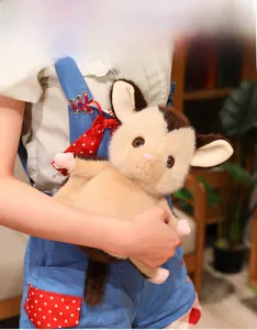 Close-up of a soft plush sugar glider toy held by a person in a cozy home setting