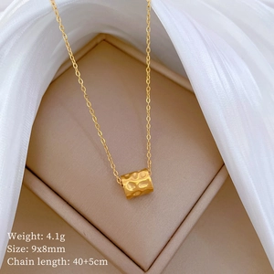 Minimalist gold plated cylinder necklace for women displayed on elegant silk background