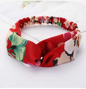 Detail of red floral elastic headband with crossover knot and soft fabric texture