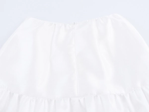 Detail of white cotton blend fabric showing pleated stitching and woven texture