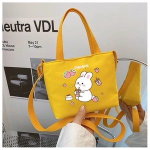 Detailed mirror view of yellow canvas kids bag featuring cute cartoon rabbit design