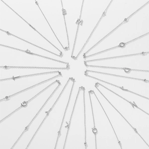 Radial display of S925 sterling silver initial necklaces with zircon stones on white backdrop